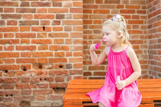 Child walks with cochlear implant system. Installation cochlear implant on child girl ear for restores hearing. Kid hears after hear return to normal. Diversity inclusion