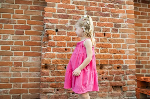 Child girl with hearing aids and cochlear implants having fun outdoor speak and playing. Copy space and empty place for advertising.