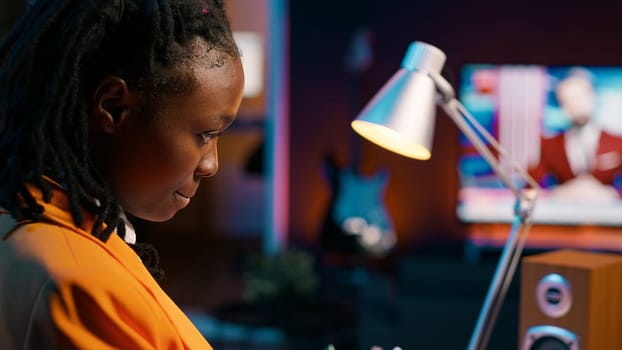 University student and coding enthusiast delves into cloud computing, expanding her knowledge beyond online class lessons. African american girl using programming language. Camera A.