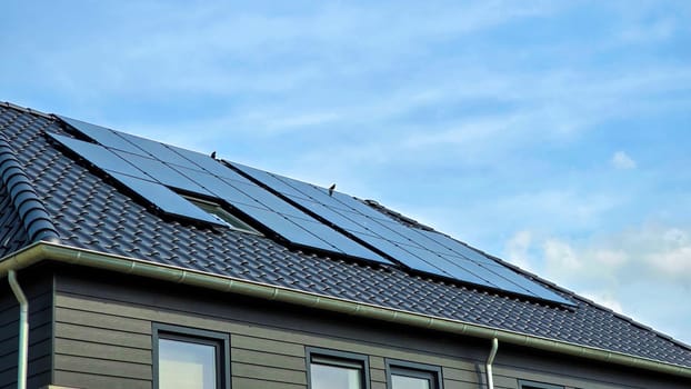 Newly built houses with black solar panels on the roof, Close up of new family home with black solar panels. Zonnepanelen, Zonne energie, Translation: Solar panel, Sun Energy