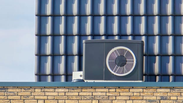 air source heat pump unit installed outdoors at a modern home with bricks in the Netherlands at spring, warmte pomp translation air source heat pump , air source heat pump on roof top