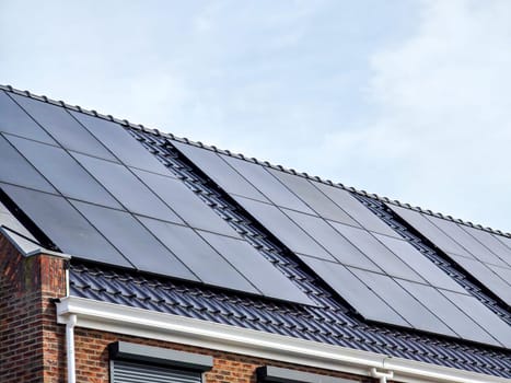 Newly built houses with black solar panels on the roof, Close up of new family home with black solar panels. Zonnepanelen, Zonne energie, Translation: Solar panel, Sun Energy