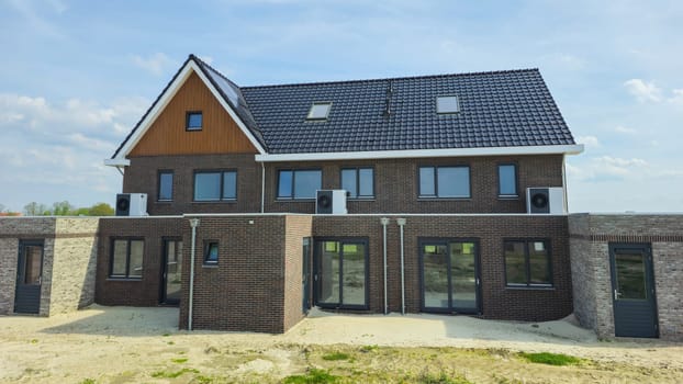 air source heat pump unit installed outdoors at a modern home with bricks in the Netherlands, warmte pomp translation air source heat pump