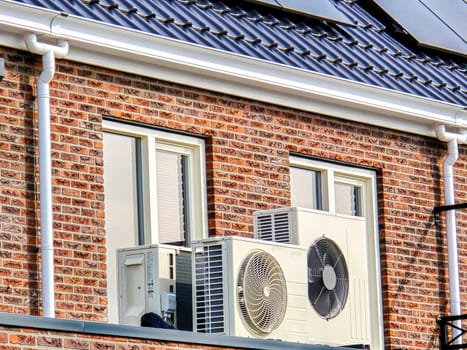 air source heat pump unit installed outdoors at a modern home with solar panels in the Netherlands, Zonnepanelen, Warmte pomp, Translation: Solar panel, Air source Heat pump