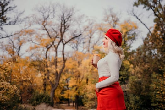 A woman in a red hat and red skirt is standing in a forest with a cup in her hand