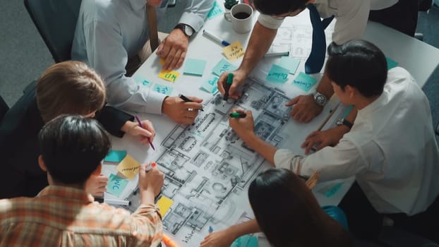 Group of diverse team planning strategy while sitting at table with project plan. Top aerial view of smart business people working together to brainstorm and design house construction. Alimentation.