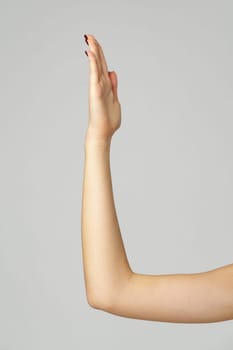 Young woman hand gesture on gray background close up