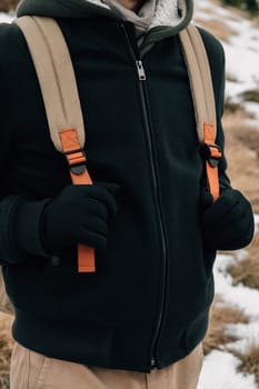 Close-up of a person dressed in winter fashion with a focus on the fleece jacket and backpack straps