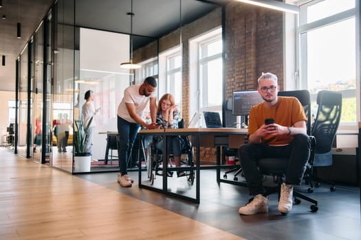 A diverse group of business professionals collaborates in a modern startup coworking center, utilizing a mix of paper-based and technological tools such as mobile phones and computers .