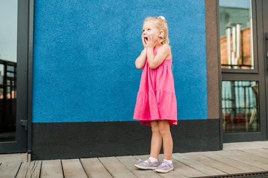 Child girl with hearing aid and cochlear implantation system. Kid with hearing problems walks outdoor in summer. Inclusion and diversity