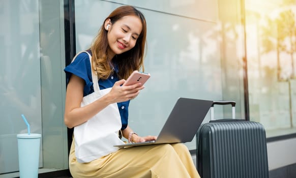 A female entrepreneur works remotely from a train station, her laptop and luggage beside her. She's always on the move, building her business from anywhere. future of work-life balance.