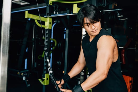 Bodybuilder performing cable triceps pulldowns during a strength training workout at the gym, building muscle and power in his arms. Upper body strength exercise