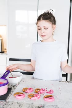 With focused attention, this budding culinary artist dips pretzels into a pot of melted chocolate, creating sweet delights in the warmth of a well-lit home kitchen.