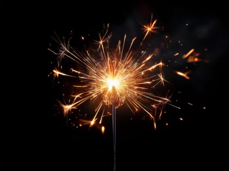 Burning sparkler on black background. Yellow golden color sparkler burnt on dark black background, isolated splash of Bengal fire, firework