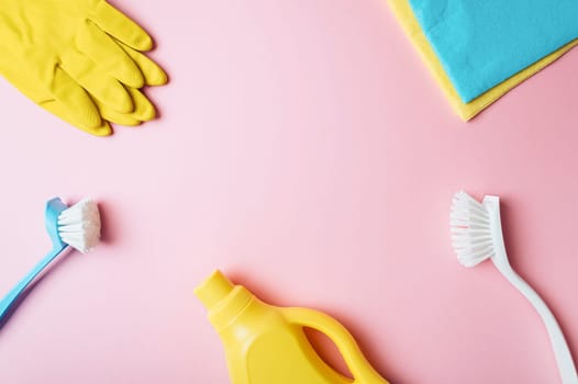 House cleaning product on pink background, copy space. Flat lay or top view. Cleaning service or housekeeping concept with space for text or design in center
