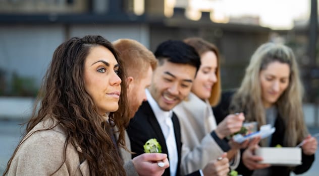 Business people on lunch time outdoors eating home made food. Corporate woman is worried and thoughtful.