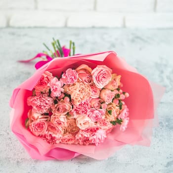 Close up view of nice subtle delicate pink bouquet with roses, dianthus, hypericum, clove. Shallow DOF. Copy space for text.