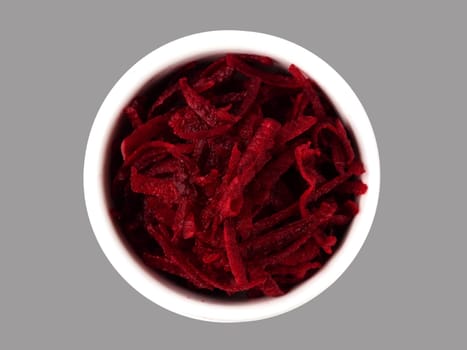 Grated beetroot in ceramic bowl. Shredded beet root salad isolated on gray. Top view or flat lay.