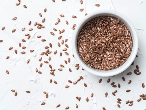 Flax seeds with copy space. Brown flax seed on white concrete textured background. Top view or flat lay. Copy space. Healthy food and diet concept