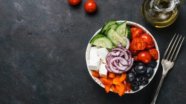 Greek Salad Bowl on dark black background, copy space. Above view of Bowl Greek Salad and ingredients. Trendy food. Idea, recept and concept of modern healthy food. Banner