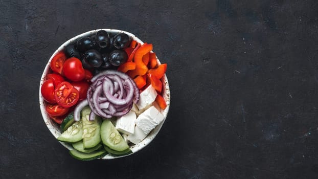 Greek Salad Bowl on dark black background, copy space. Above view of Bowl Greek Salad. Trendy food. Idea, recept and concept of modern healthy food. Banner