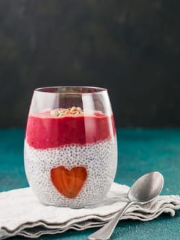 Idea for healthy breakfast on Valentine's Day: Chia pudding with red berry puree, chopped almonds on top and strawberry in the shape of heart. Copy space for text