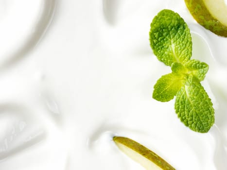 greek yogurt or sour cream texture with pear slice and mint leaf. Close up with copy space. Top view or flat lay