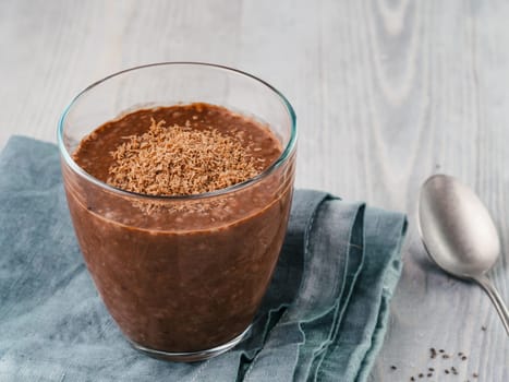 Chocolate chia pudding in glass on gray wooden table. Healthy vegan breakfast with copy space.