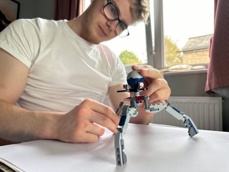 Selective focus on a constructor toy in the hands of a handsome young man