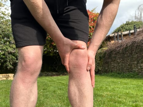 Cropped shot of a man holding his aching injured knee