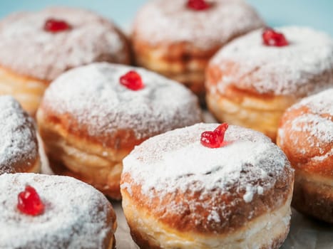 Hanukkah food doughnuts with jelly and sugar powder on blue background. Jewish holiday Hanukkah concept and background. Copy space for text. Shallow DOF