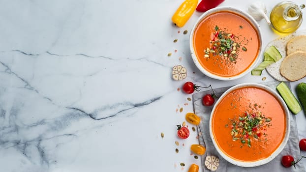 Gaspacho soup on white marble tabletop. Two bowls of traditional spanish cold soup puree gaspacho or gazpacho on light gray marble background.Copy space for text or design.Top view or flat lay.Banner