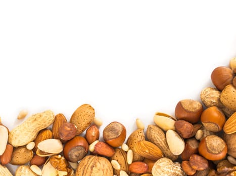 Background of mixed nuts - hazelnuts, almonds, walnuts, pistachios, peanuts, pine nuts peeled and not peeled - vertical with copy space. Isolated one edge. Top view or flat lay