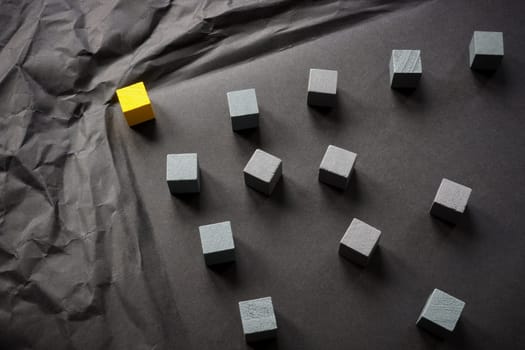 Crumpled paper and yellow cube as a leader overcomes obstacles.