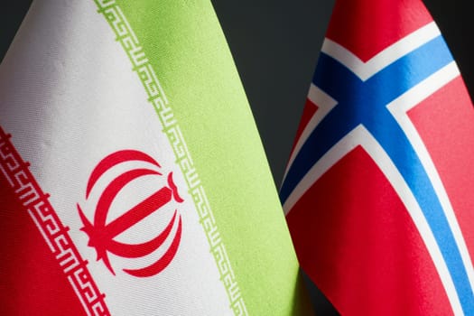 Small flags of Iran and Norway next to each other.