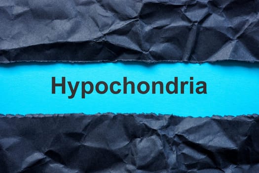 Torn black paper and word hypochondria on the blue surface.