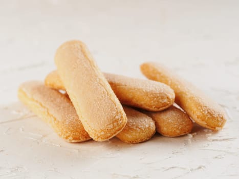 Close up view of ladyfinger biscuit cookie on white concrete background. Italian cookie savoiardi.