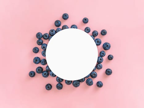 Creative layout with fresh ripe berries. Blueberry on pink background with round white circle in center for copy space. Can use for your design, promo, social media, Top view. Horizontal