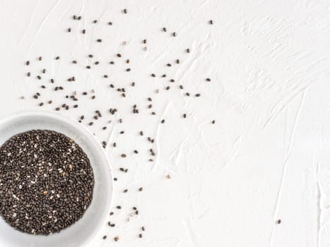 Chia seeds with copy space. Chia seed on white concrete textured background. Top view or flat lay. Copy space. Healthy food and diet concept