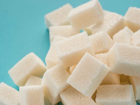 Background of sugar cubes. White cube sugar on blue background. White sugar close up