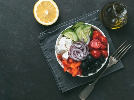 Greek Salad Bowl on dark black background, copy space. Above view of Bowl Greek Salad. Trendy food. Idea, recept and concept of modern healthy food. Toned image.