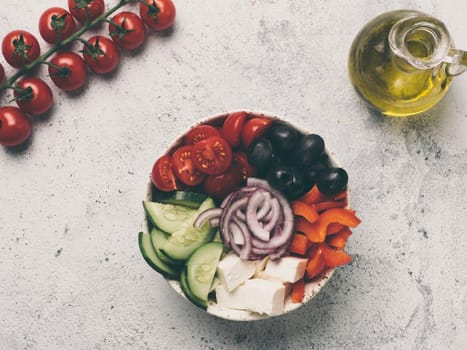 Greek Salad Bowl on gray cement background, copy space. Above view of Bowl Greek Salad. Trendy food. Idea, recept and concept of modern healthy food. Toned image.