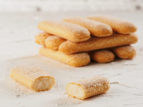 Close up view of ladyfinger biscuit cookie on white concrete background. Italian cookie savoiardi.