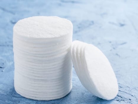 cotton pads on blue concrete background close up