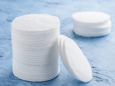 cotton pads on blue concrete background close up