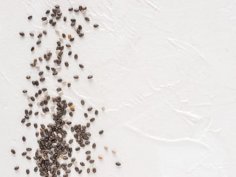 Chia seeds with copy space. Chia seed on white concrete textured background. Top view or flat lay. Copy space. Healthy food and diet concept