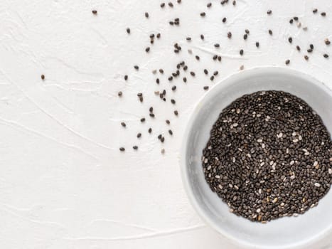 Chia seeds with copy space. Chia seed on white concrete textured background. Top view or flat lay. Copy space. Healthy food and diet concept