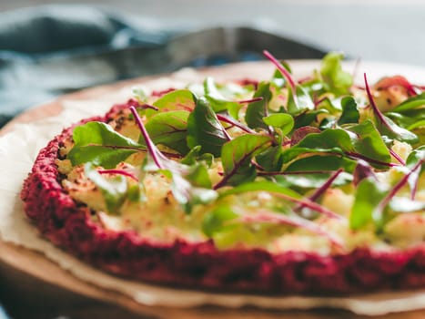 beetroot pizza crust with fresh swiss chard or mangold, beetroot leaves. Ideas and recipes for vegan snack.Egg-free pizza crust with chia seeds and wholegrain brown rice flour. Copy space. Shallow DOF