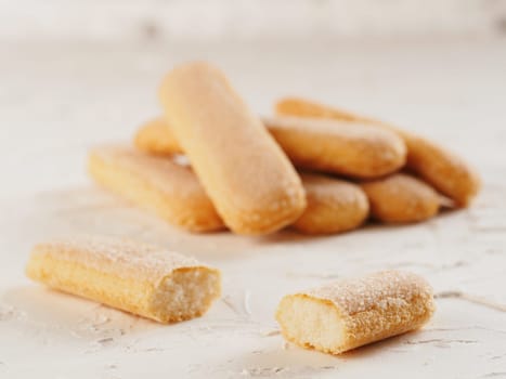 Close up view of ladyfinger biscuit cookie on white concrete background. Italian cookie savoiardi.