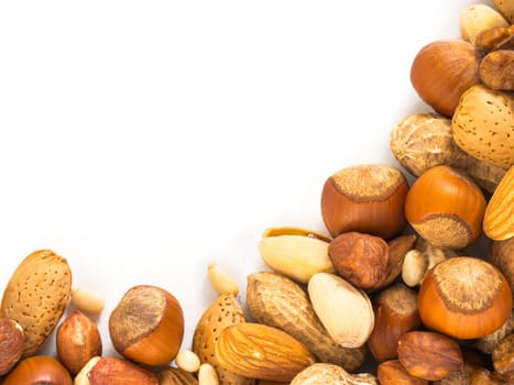 Background of mixed nuts - hazelnuts, almonds, walnuts, pistachios, peanuts, pine nuts peeled and not peeled - vertical with copy space. Isolated one edge. Top view or flat lay